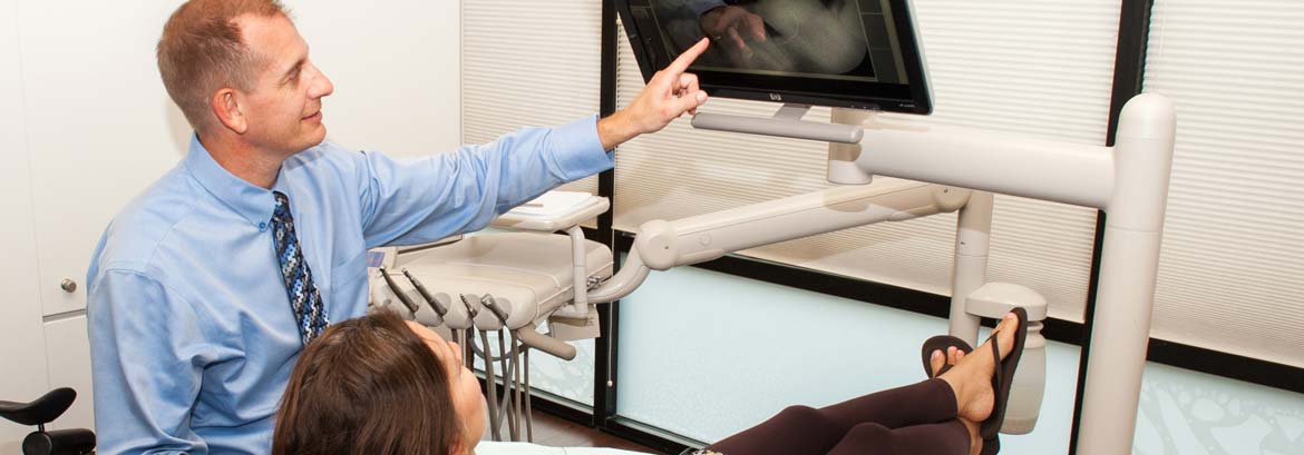 Dentist performing ultrasound examination on patient in modern dental office clinic.