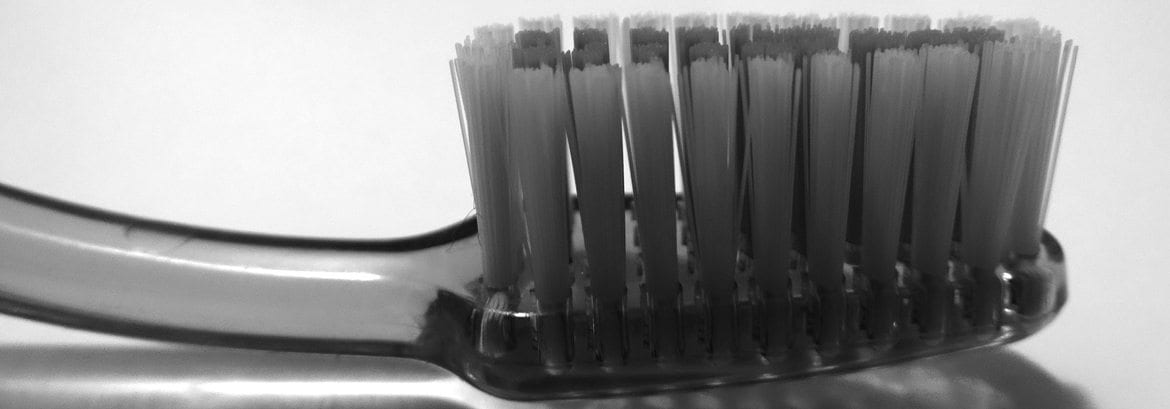 Close-up of black toothbrush bristles against white background, dental care product.