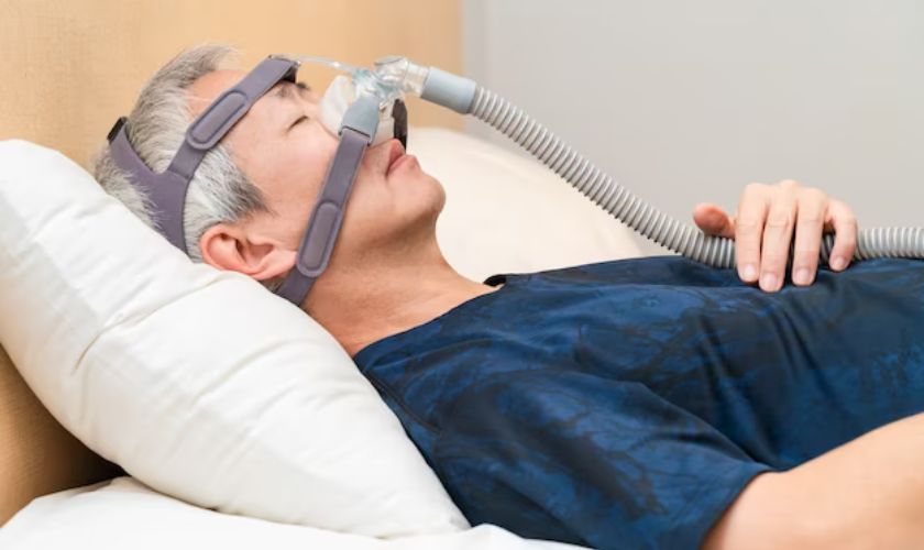 Man wearing CPAP mask in bed for sleep apnea treatment