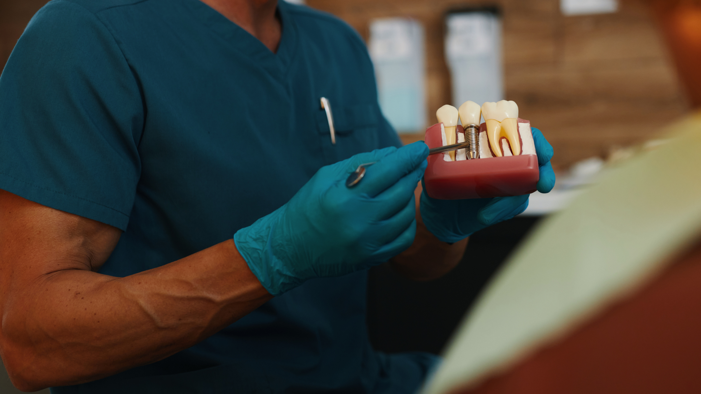 Dentist demonstrating a dental implant model to explain implant care and structure