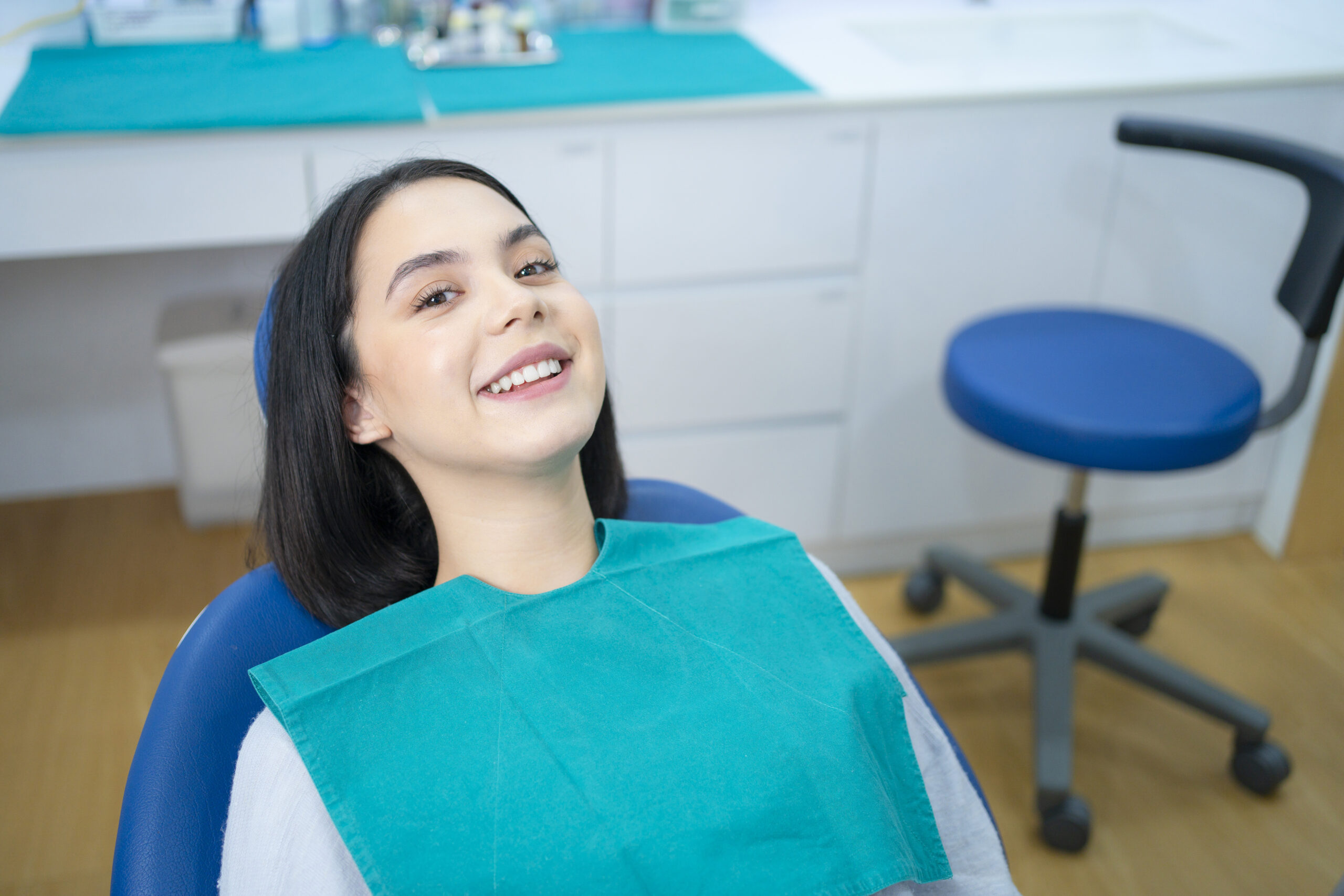 Young patient smiling comfortably in a dental chair during a routine visit at a dental clinic